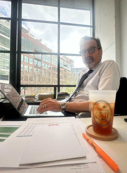 Sid in his office on his laptop, drinking an Arnold Palmer out of a cup with the Master's logo.